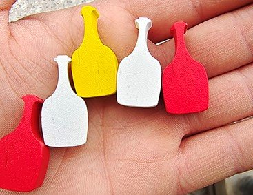 Painted wooden game pieces in solid red yellow and white colors for custom board game components